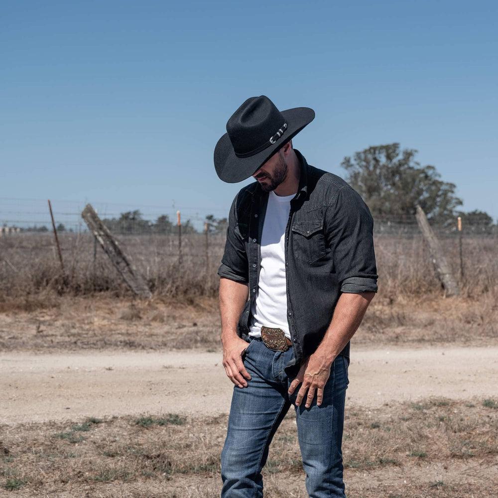 A man on the road wearing Black Cattleman Felt Cowboy Hat