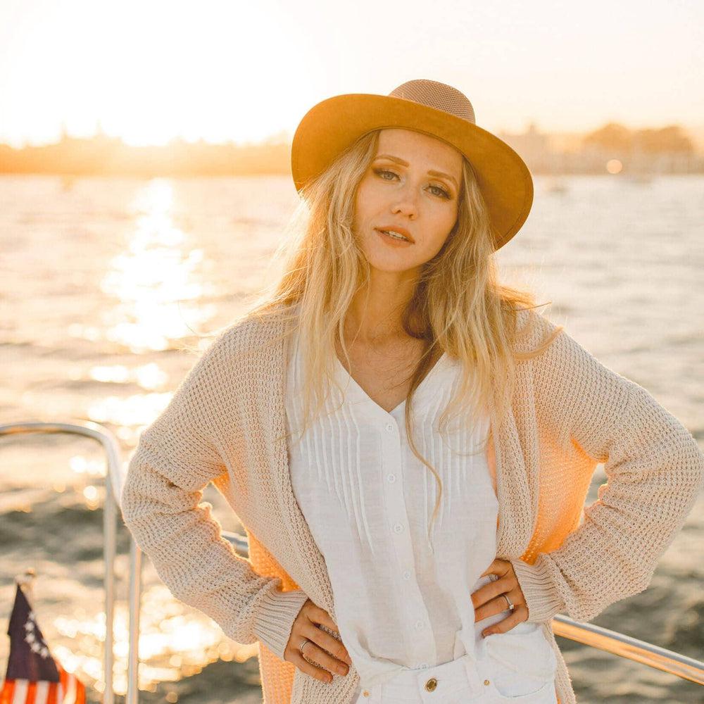 A woman on a boat wearing copper leather hat