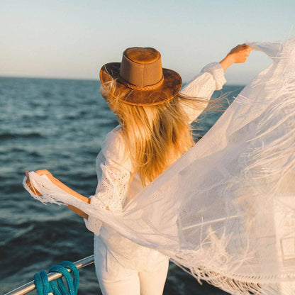 A woman in a boat wearing Copper Leather Mesh Sun Hat facing the ocean view