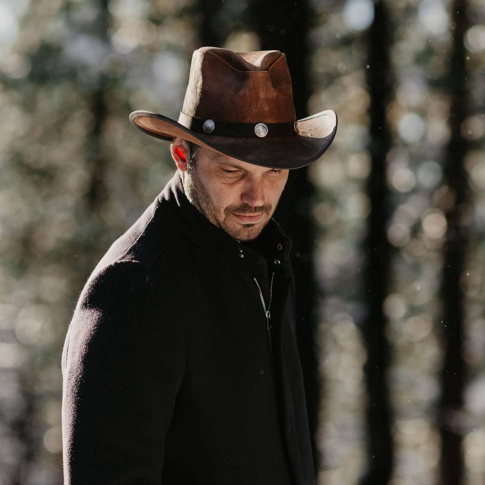 A man walking in the forest wearing Cobblestone Leather Cowboy Hat with 3" Brim and 4" Crown 