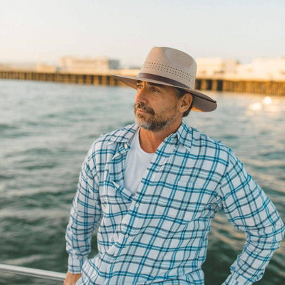 A man on the boat looking far away wearing Straw Sun Hat 