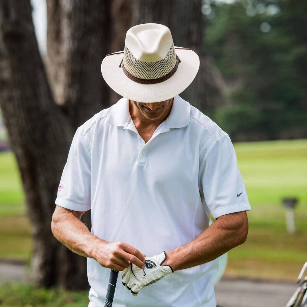 Man golfing while wearing the cream mens milan sun hat