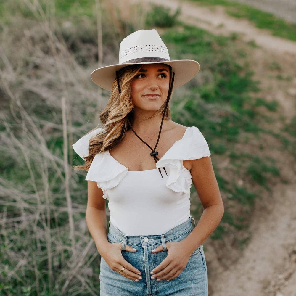 A woman standing outdoors wearing Barcelona Cream Straw Sun Hat 