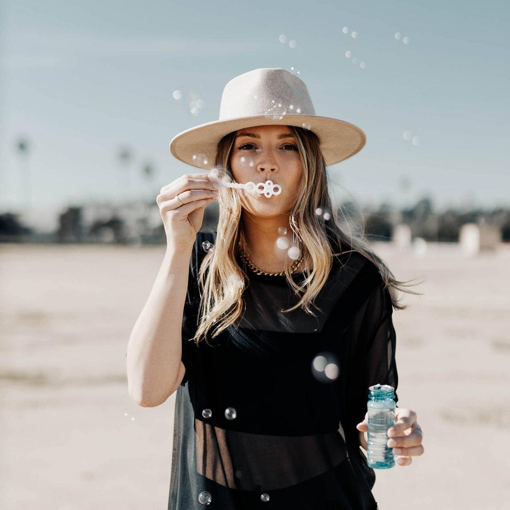 A woman playing bubble wearing Bondi Oatmeal Wide Brim Felt Fedora 