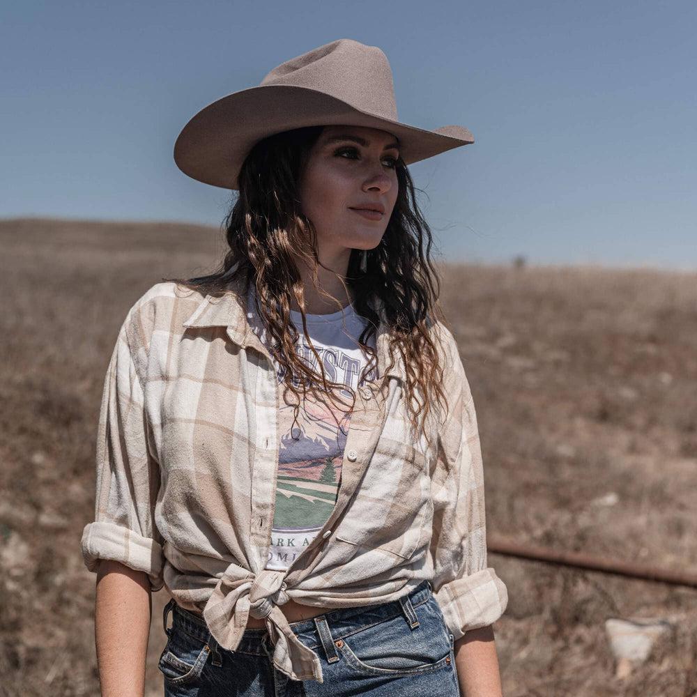 A woman in a checkered top and a Felt Cowboy Hat 