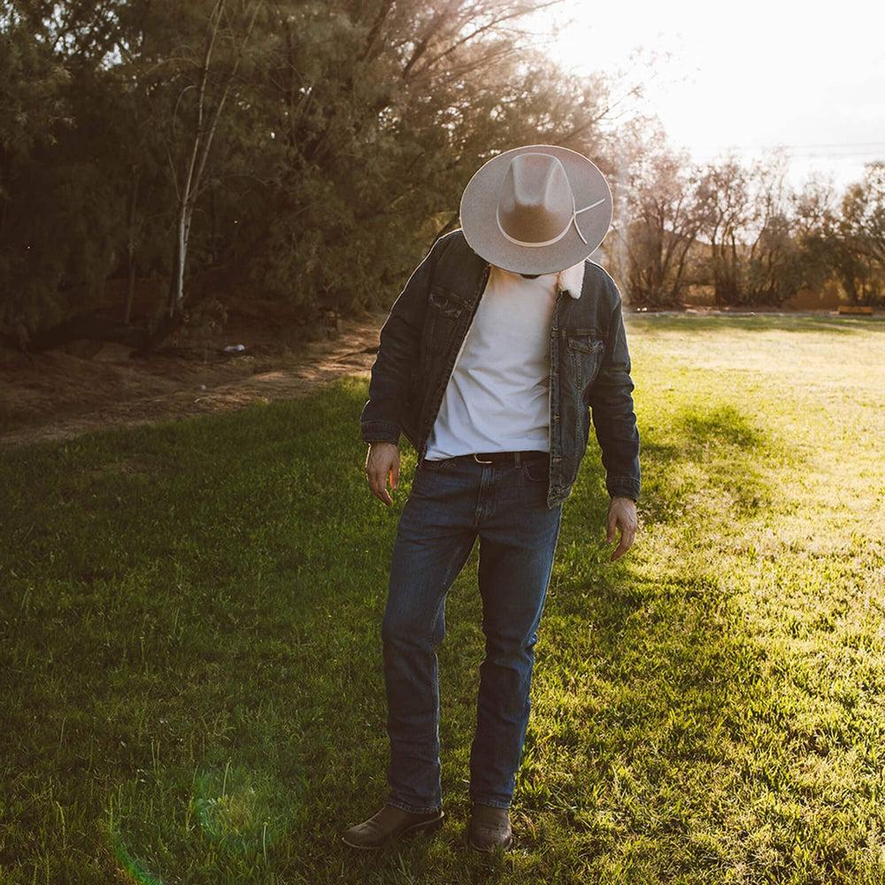 A man standing in a yard wearing Crescent Oatmeal Felt Wool Fedora Hat 