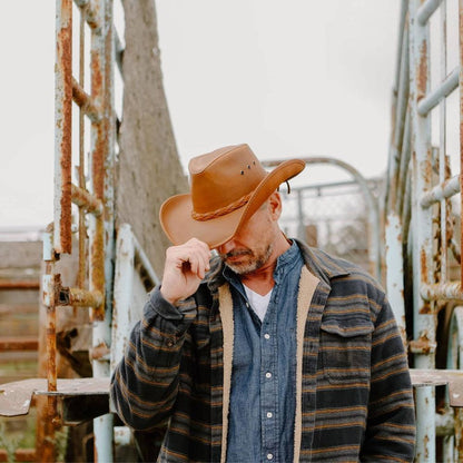 man standing in cattle pen wearing the Hollywood Copper Leather Cowboy Hat by American Hat Makers