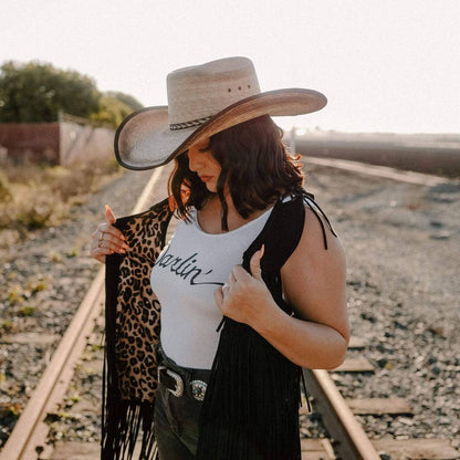 A woman in a railway track wearing Laredo Straw Tan Cowboy Hat 