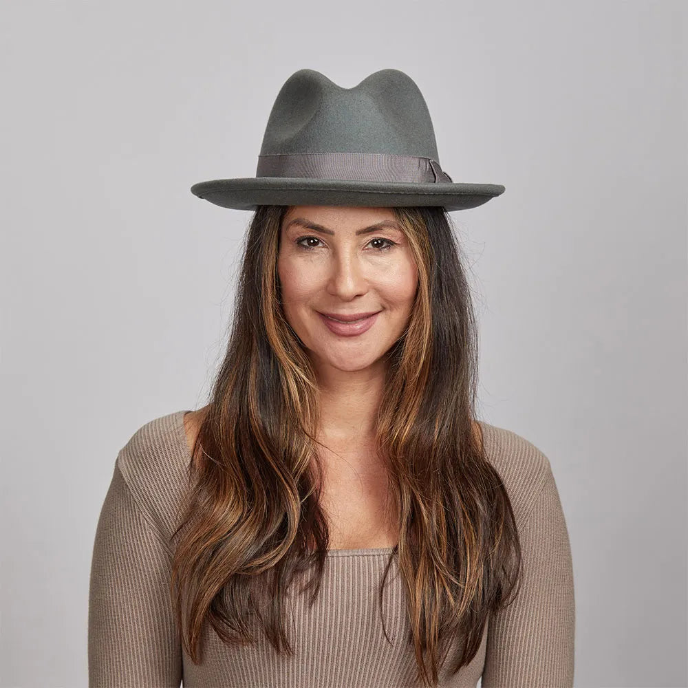 Smiling woman wearing a grey Pablo felt hat and a light brown sweater