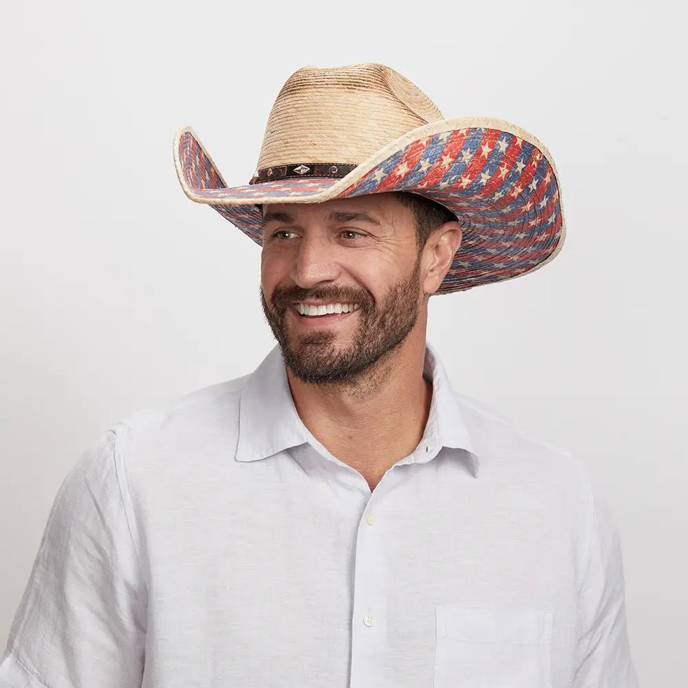 A smiling man wearing a Patriot sombrero with a patterned brim.