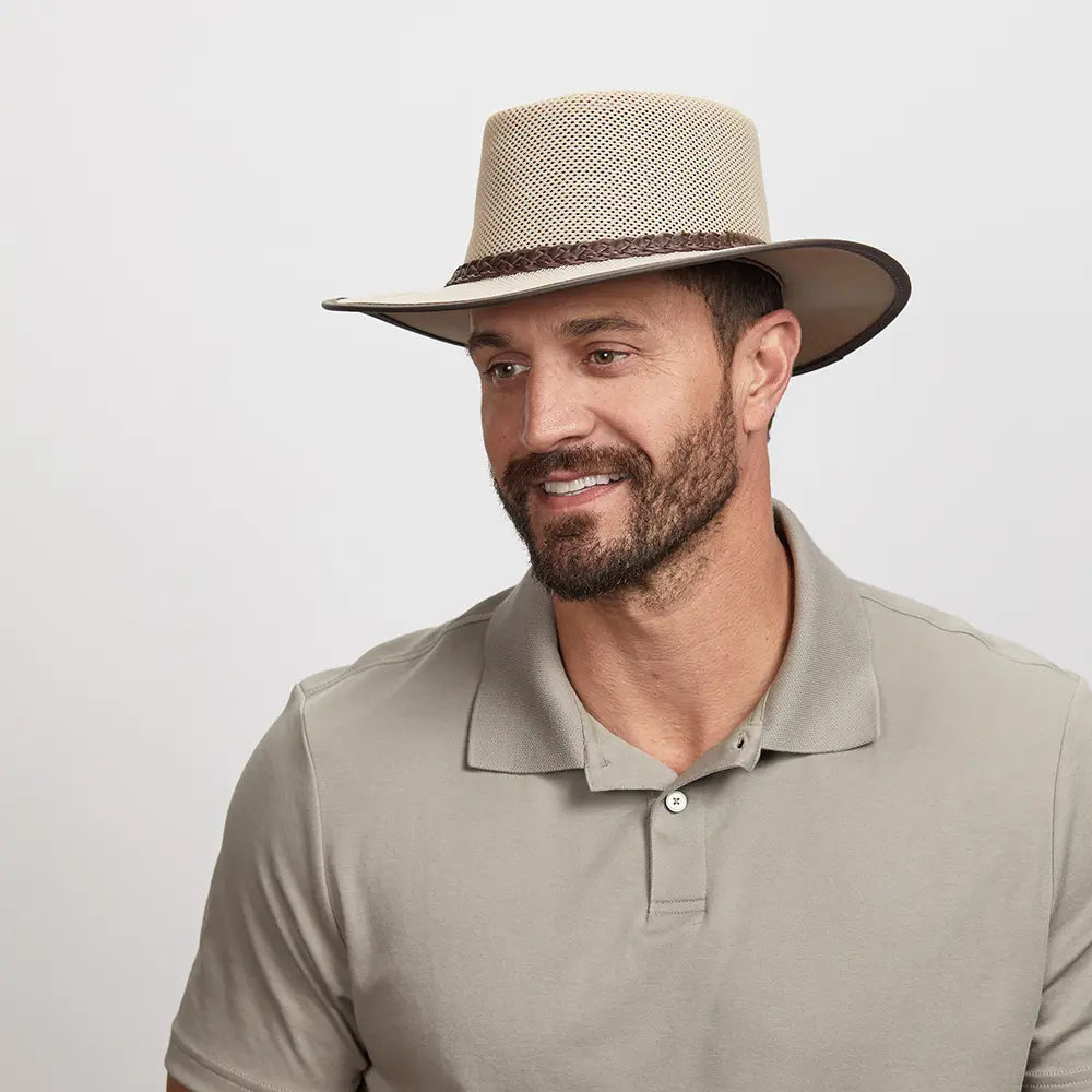 Man wearing a beige mesh fedora and a light beige polo shirt.