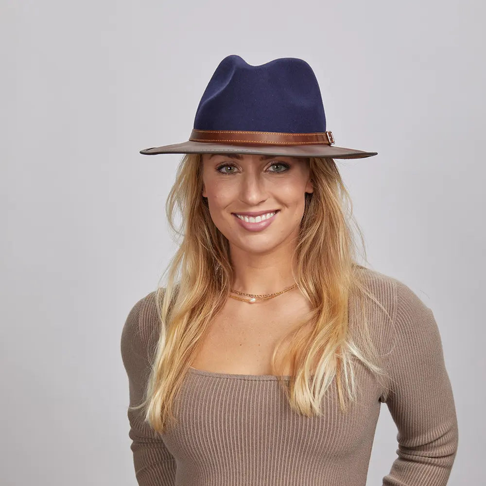 A blonde woman wearing a Navy Felt Fedora Hat and a beige fitted top.