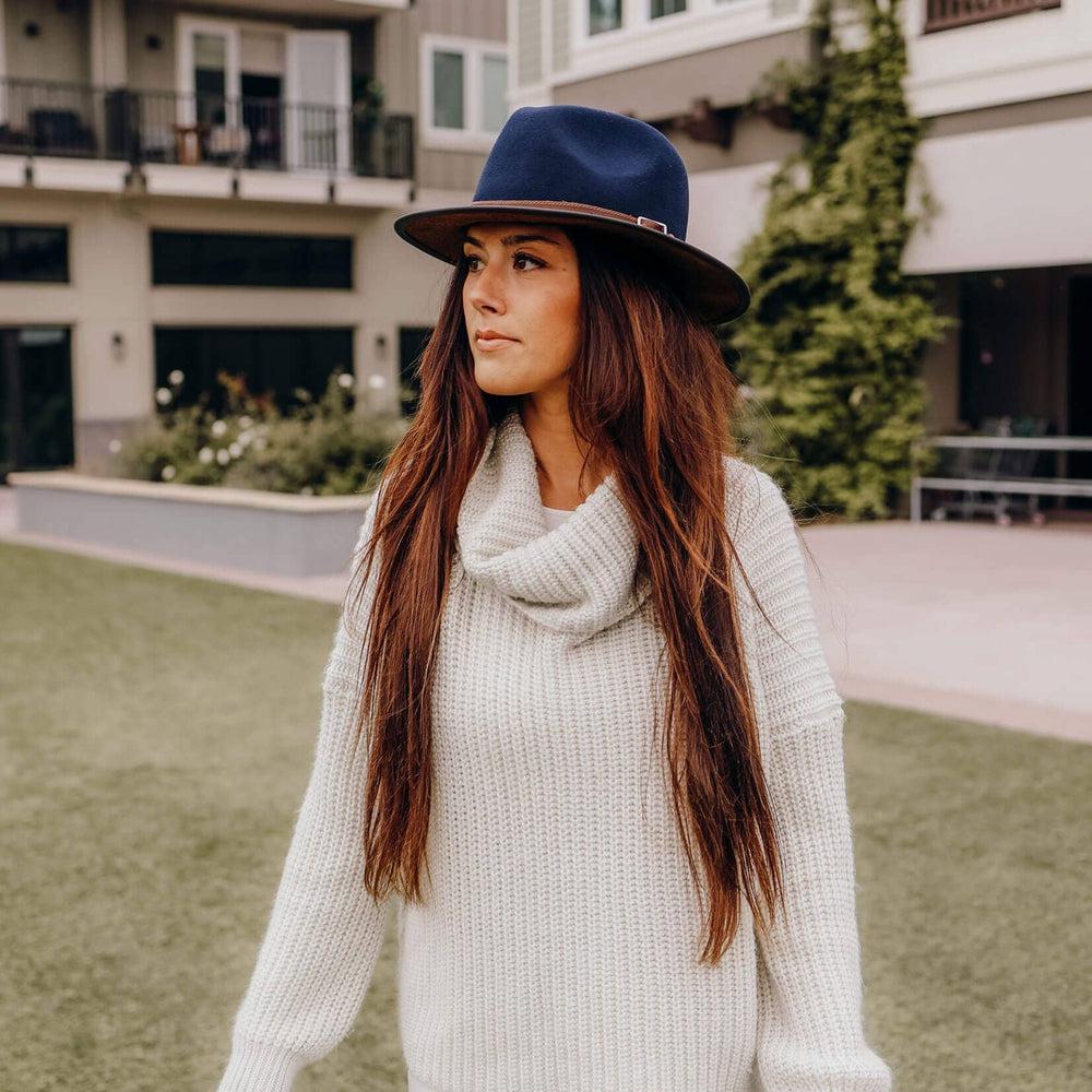 A woman standing outdoors wearing Summit Navy Leather Felt Fedora Hat 