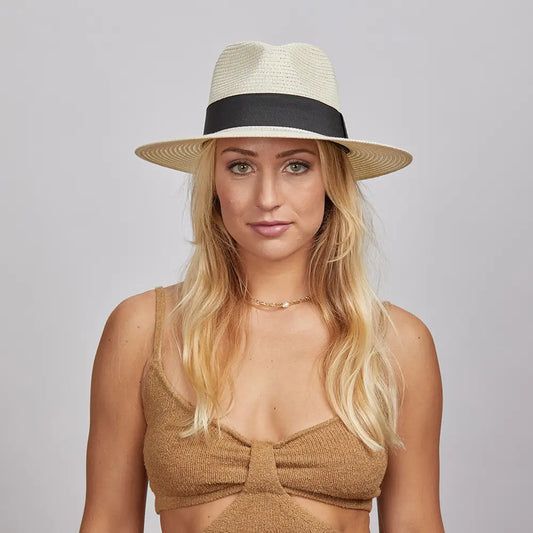 A blonde woman wearing a Cream Afternoon Fedora Hat and a brown knitted top.