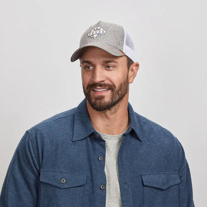 A man wearing a gray Texas cap and blue button-up shirt 