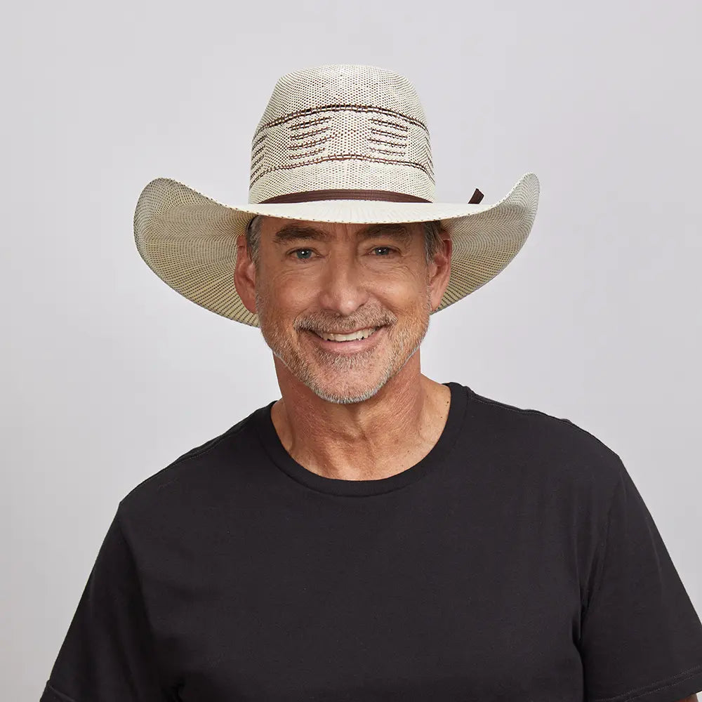 A smiling man wearing a black shirt and a straw cowboy hat