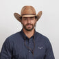 A smiling man in a navy blue polo wearing the Toast Cowboy Hat