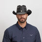 A man in a dark blue polo wearing the Western Black Leather Cowboy Hat