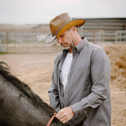 A man fixing a horse rope wearing Cyclone Burnt Honey Leather Cowboy Hat