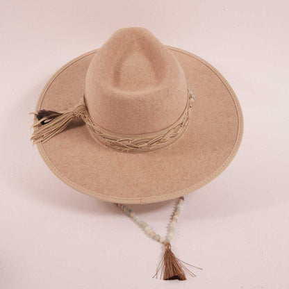 A top view of a cream cowboy hat with a beaded hat band